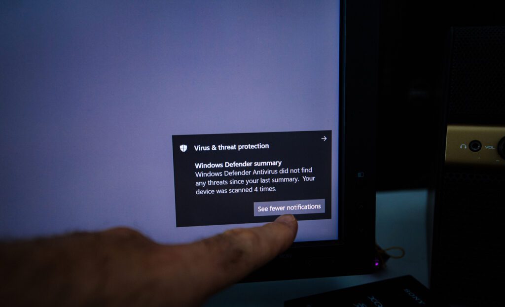 Man hand pointing to virus and threat protection during Microsoft defender antivirus